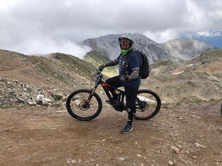 Biker mit E-Mountainbike vor Bergpanorama